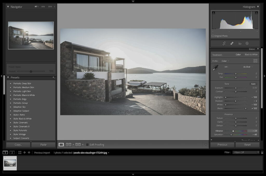 A brown concrete house with a glass window near the calm beach being edited in Lightroom