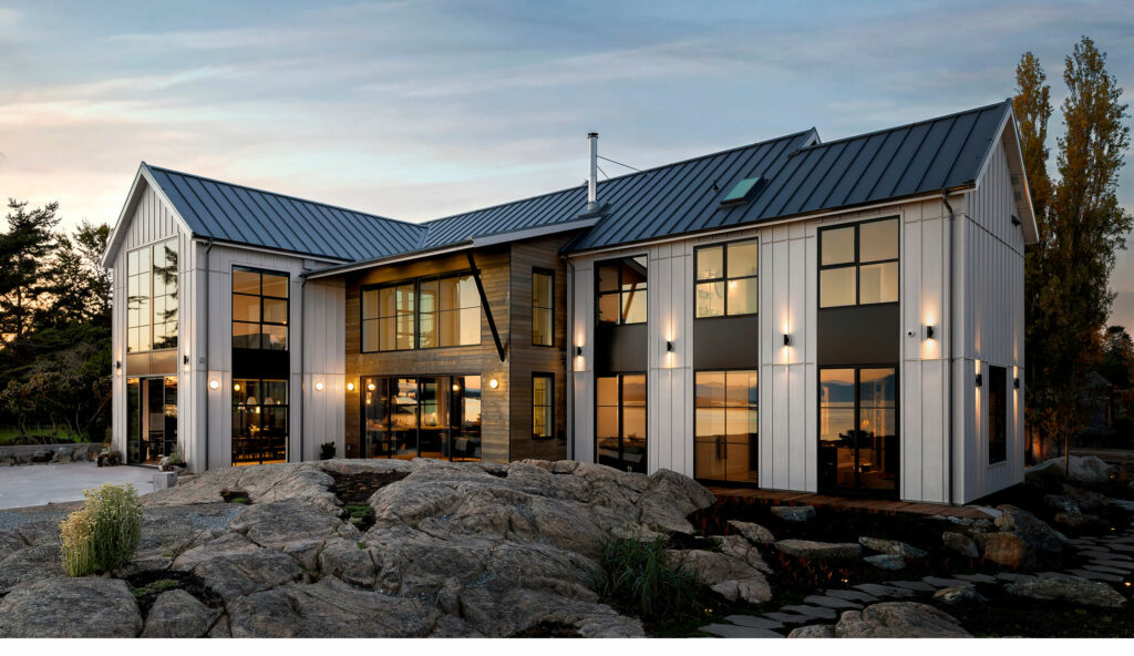 Two story house with white exterior and a rocky pond design