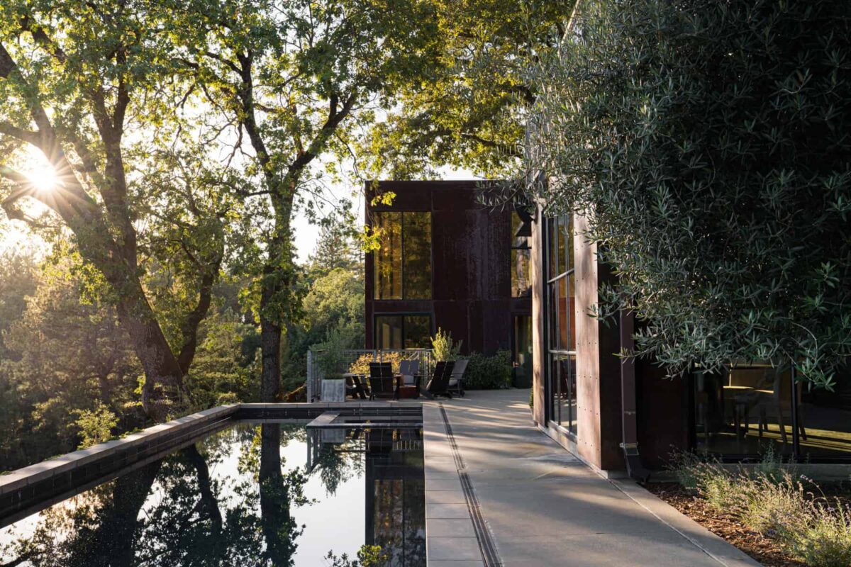 Casa a due piani costruita con lussureggianti alberi verdi e piscina e girata durante l'ora d'oro