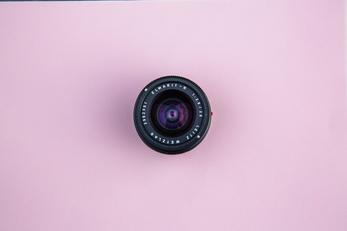 A top view of the Leitz Wetzlar lens with a 28mm lens placed on a pink surface