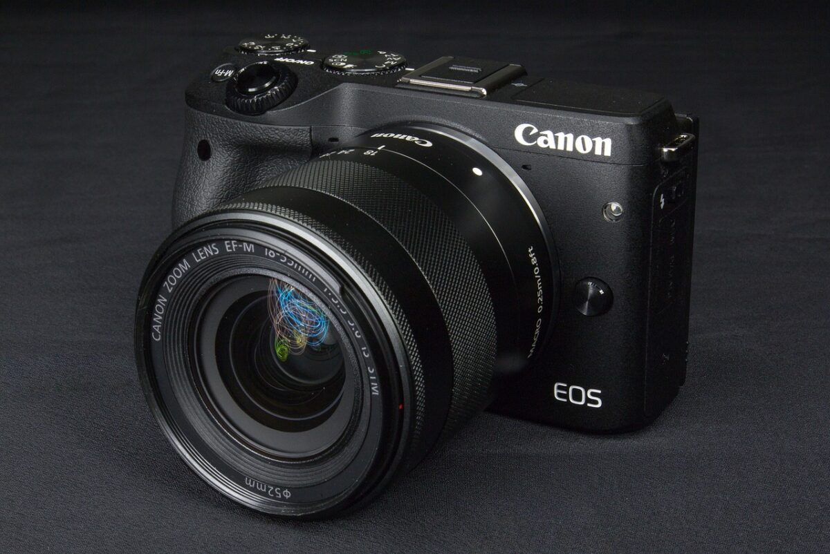 A close-up view of a black Canon DSLR camera placed on a black surface