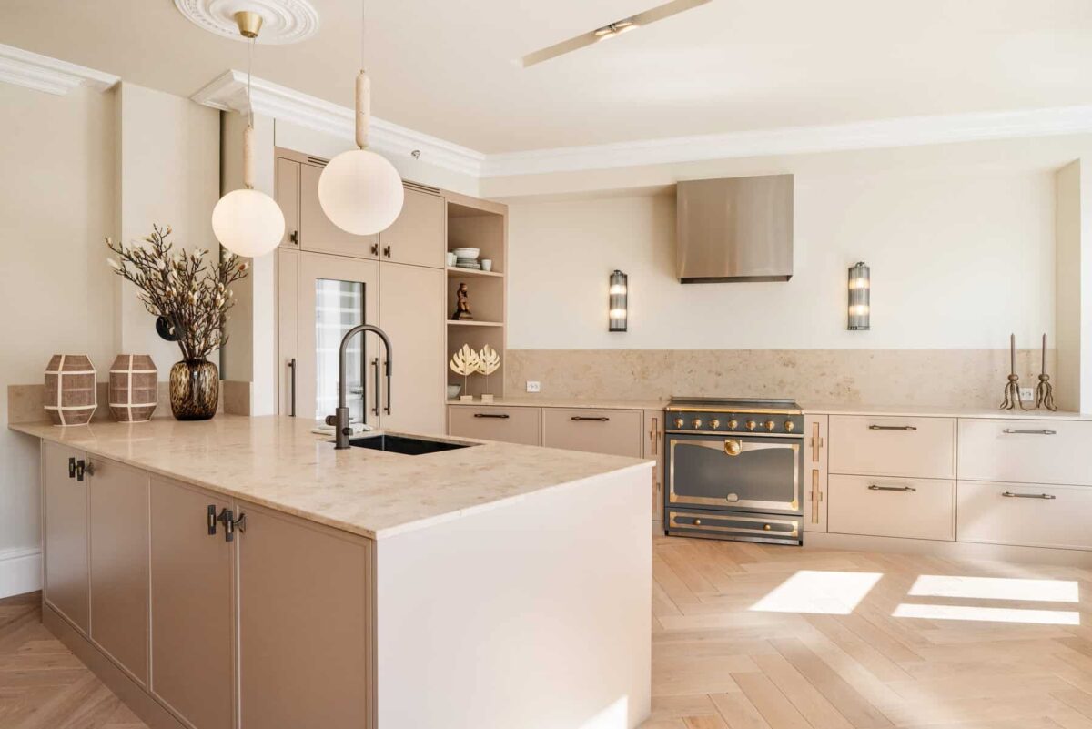 A modern kitchen featuring a large island, elegant light fixtures, and high-end appliances.