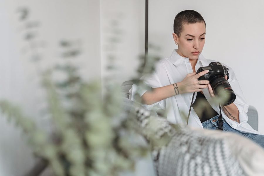 Donna che esamina le sue immagini sulla sua macchina fotografica