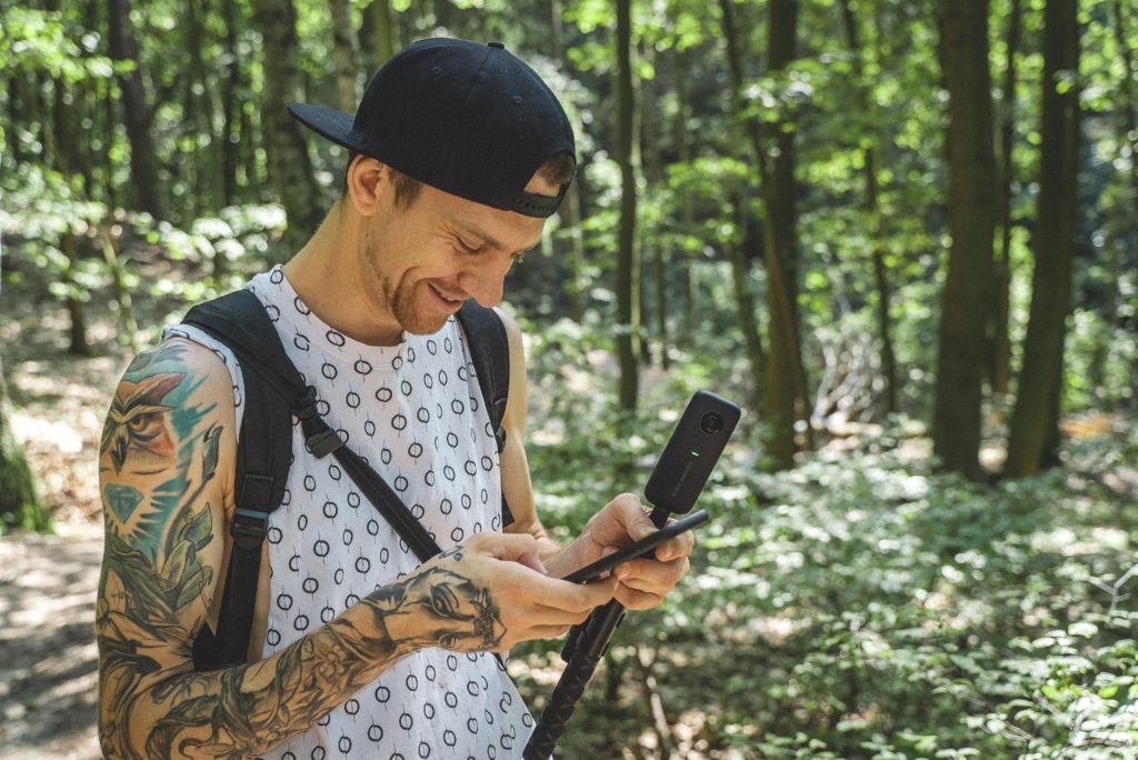 Homem olhando para cima o que é uma câmera 360 em seu telefone