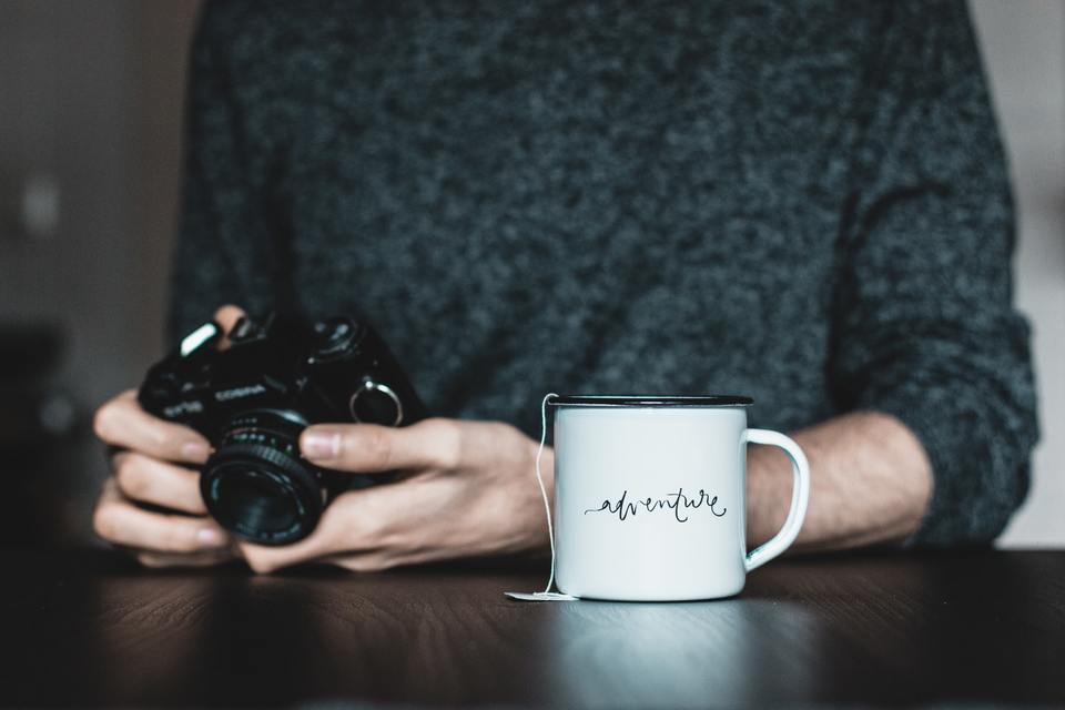 Person holding a camera near mug