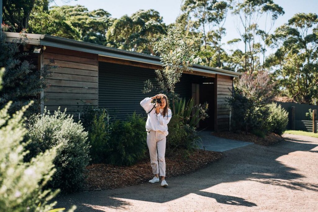 Woman taking a photo right in front of a house