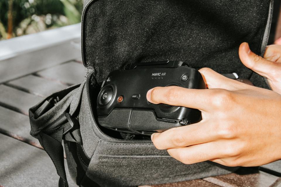 Person putting drone controller inside backpack