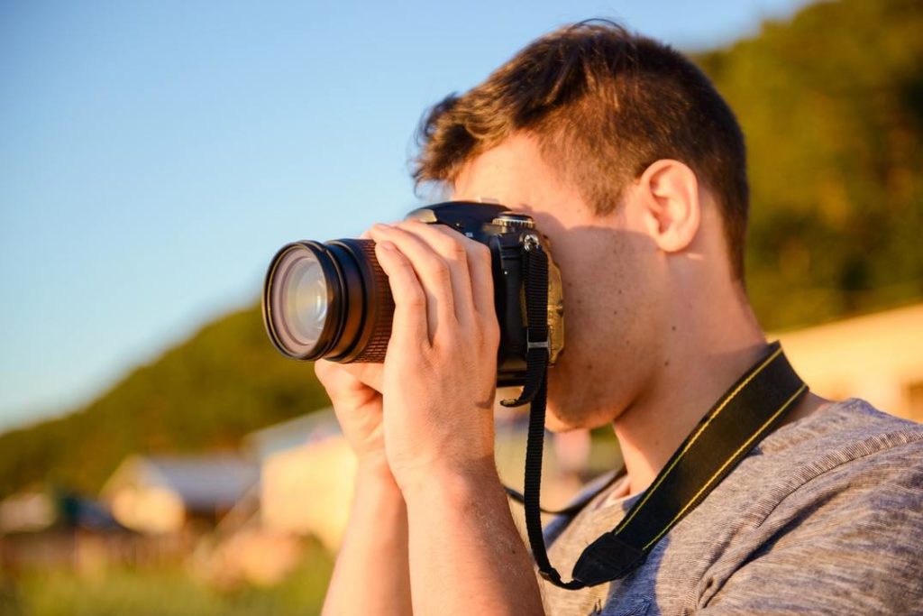 Uomo che utilizza una macchina fotografica all'aperto