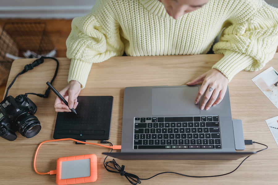 Una donna impegnata a modificare le immagini sul suo MacBook