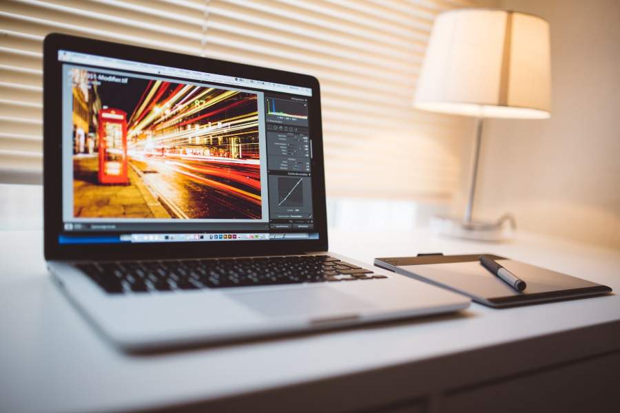 A tablet beside a laptop with Adobe Lightroom program