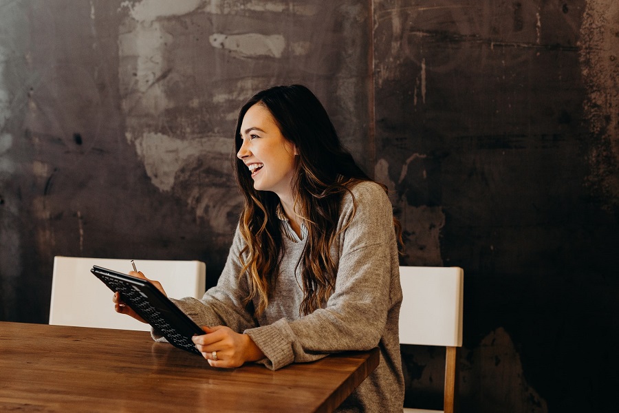 A smiling woman holding a tablet