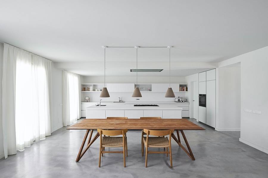 Real estate shot of all white kitchen interior and wooden dining set