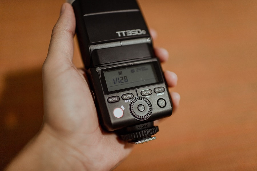 Person holding a camera flash